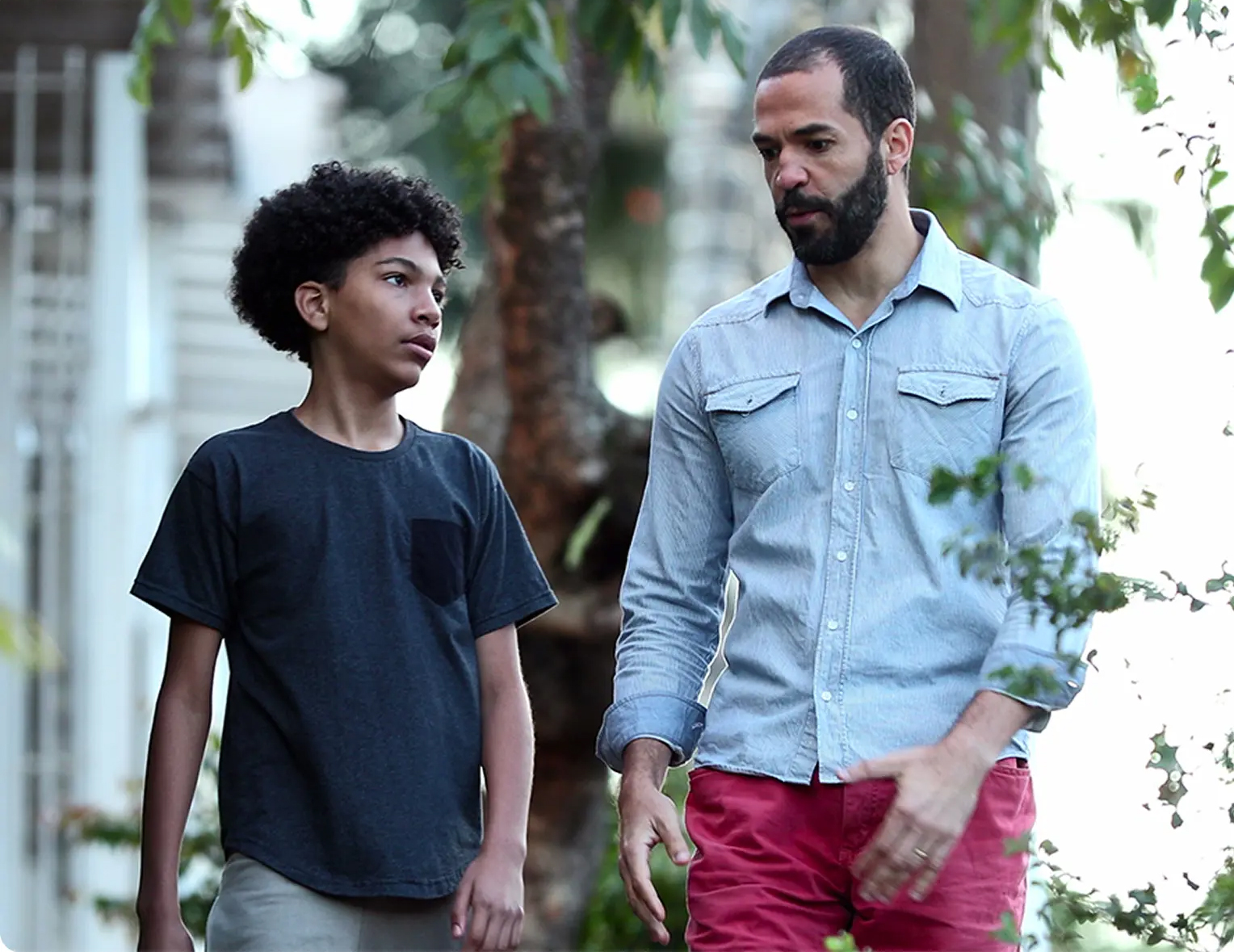 man and young boy walking and talking